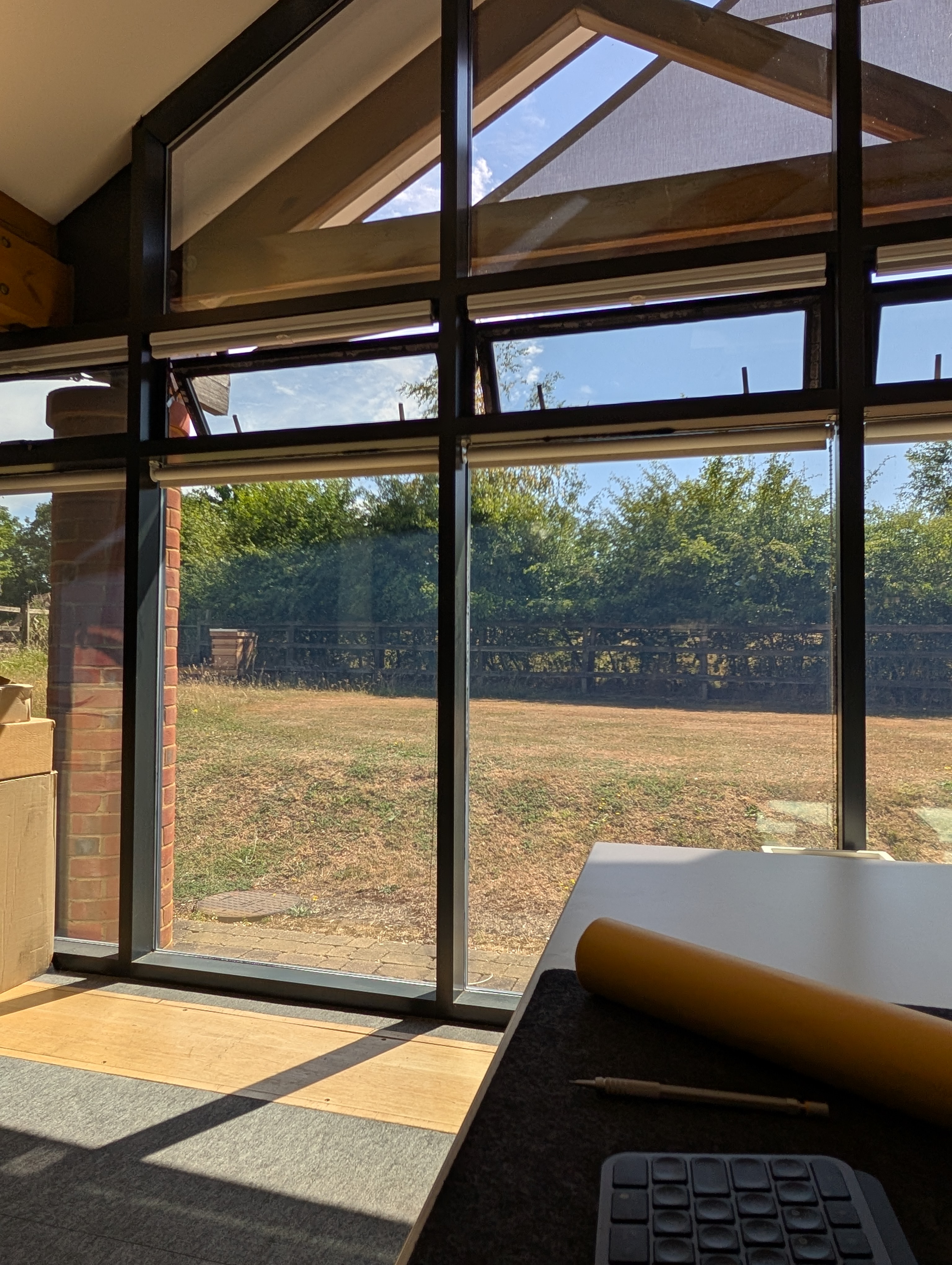 You can see the wooden structure  of their office and beyond this grass and trees