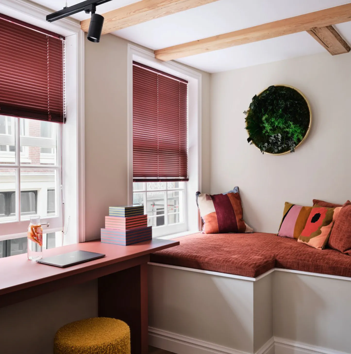 About Corner snug of office with rust coloured desk, cushions and blinds - About.