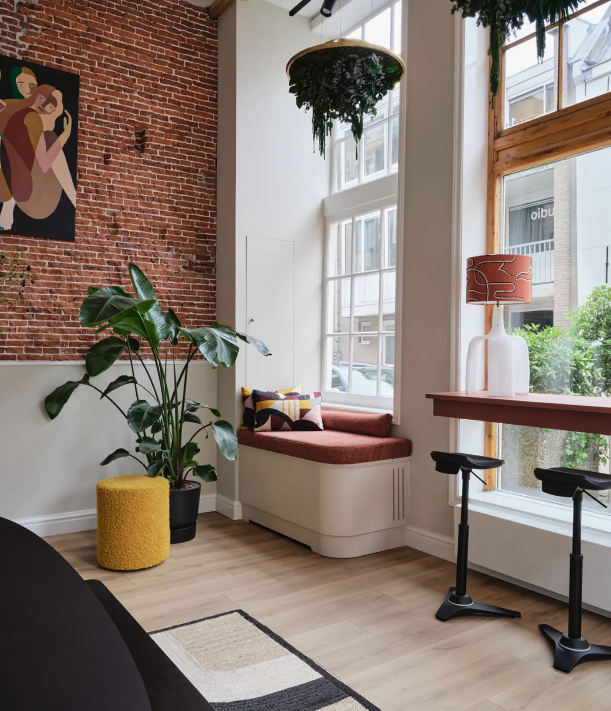 Bright office space with hanging ceiling plants - About