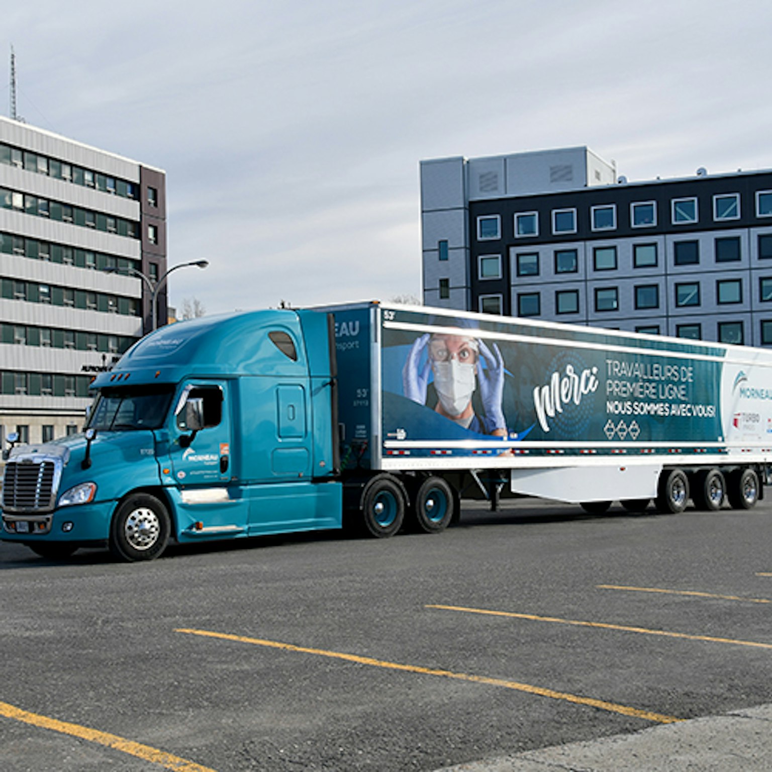A Groupe Morneau truck with a visual thanking frontline workers sits in a parking lot.