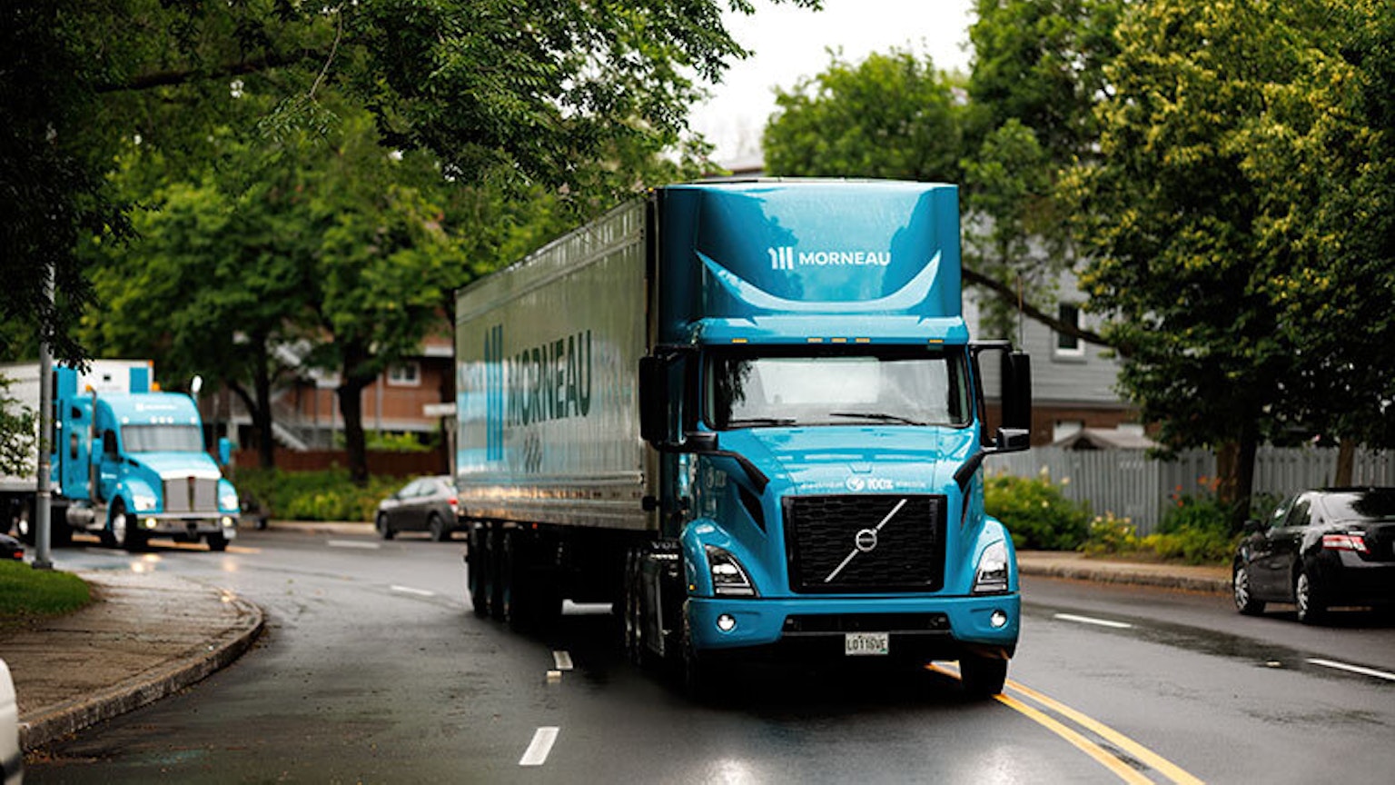 Le premier camion 100% électrique du Canada, propriété du Groupe Morneau, suivi par un deuxième camion de la flotte de l’entreprise.