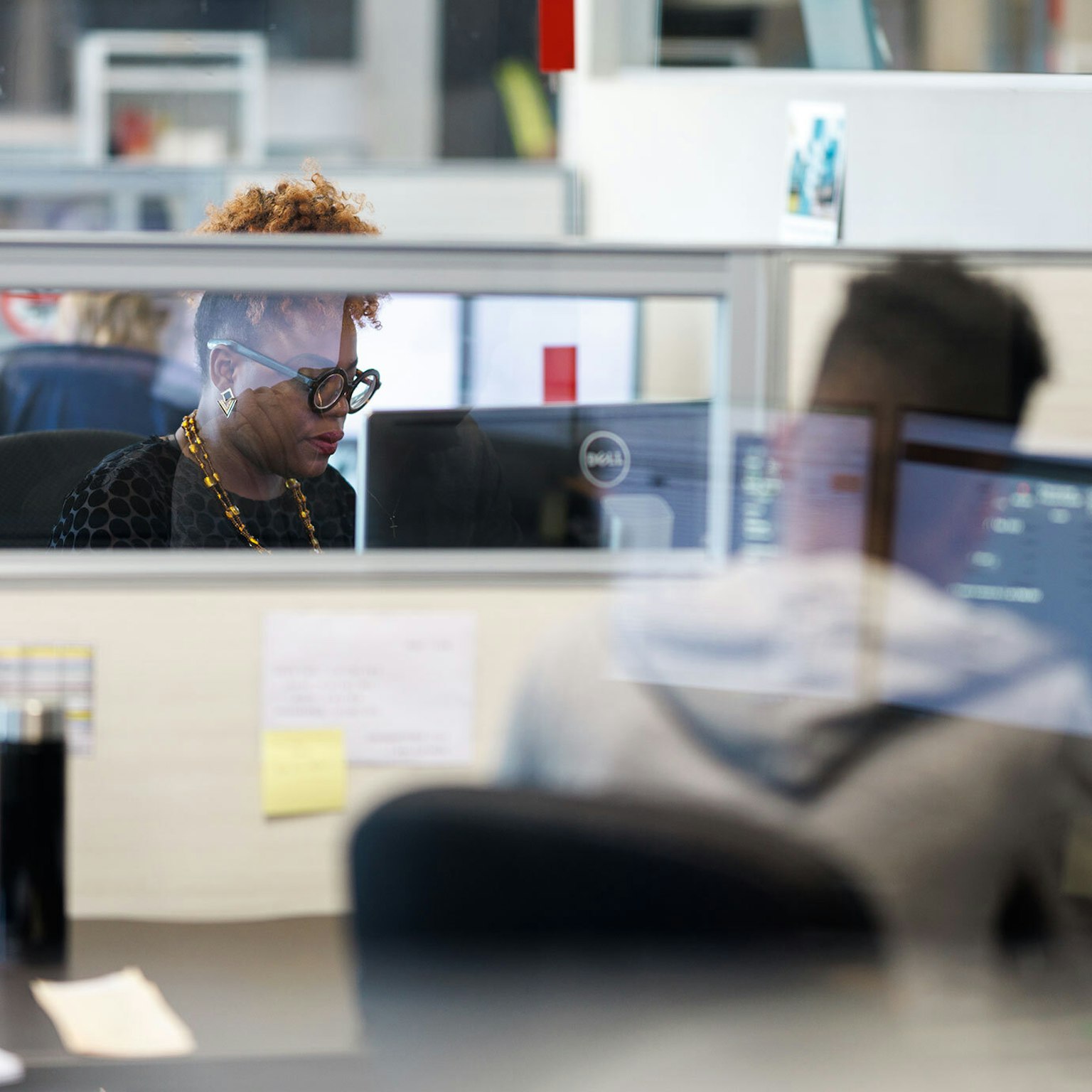 Two administrative collaborators from Groupe Morneau working in front of their respective desk’s computers.