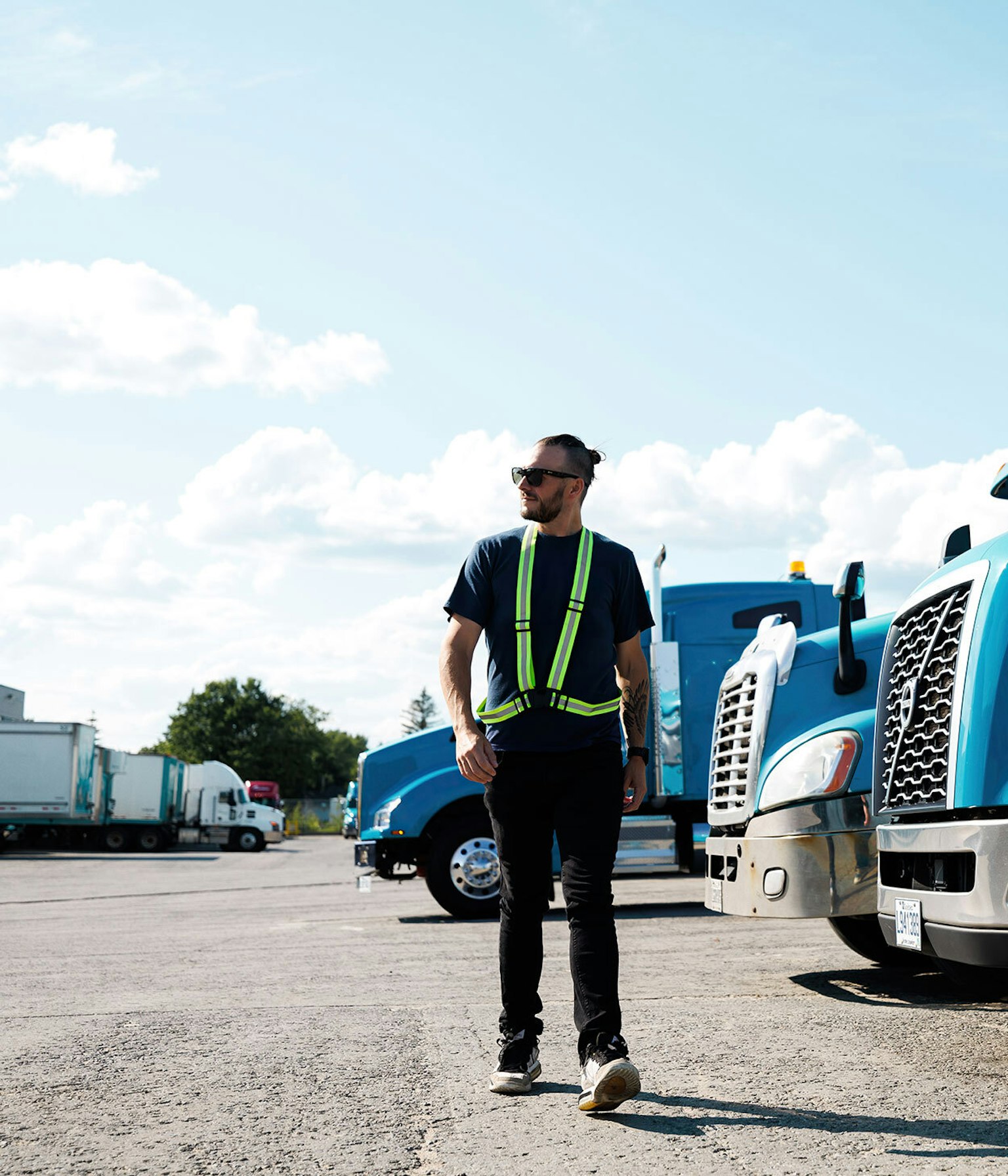 Un conducteur du Groupe Morneau marchant devant des camions stationnés à un des terminaux.