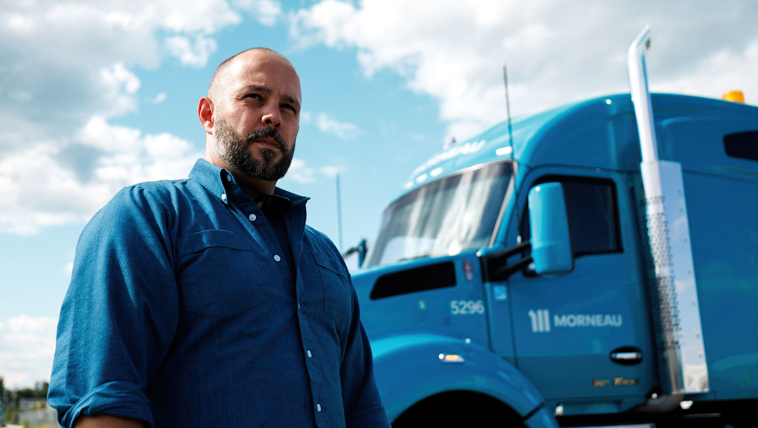 Un employé du Groupe Morneau pose devant un camion