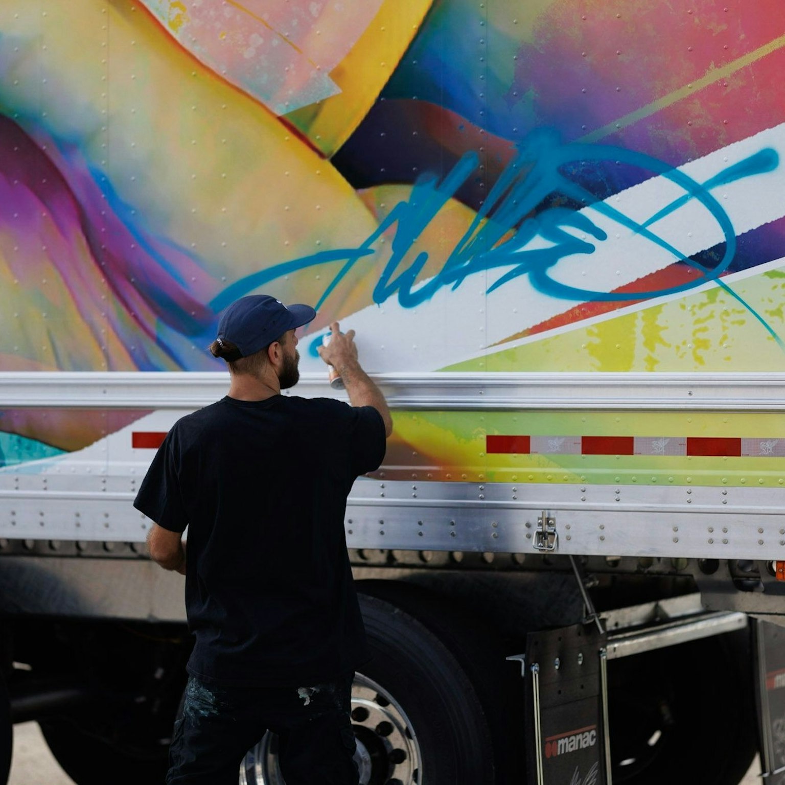 Artiste Fluke travaillant une fresque sur la remorque d'un camion pour le 80ème anniversaire Morneau