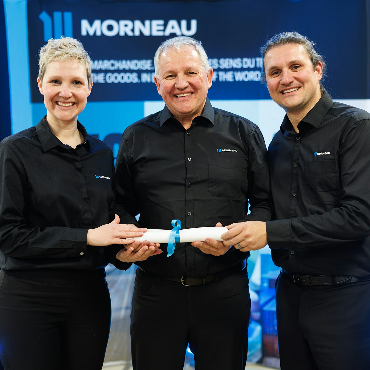 Catherine, André et David Morneau lors de la remise symbolique d'un parchemin, marquant cette passation historique.