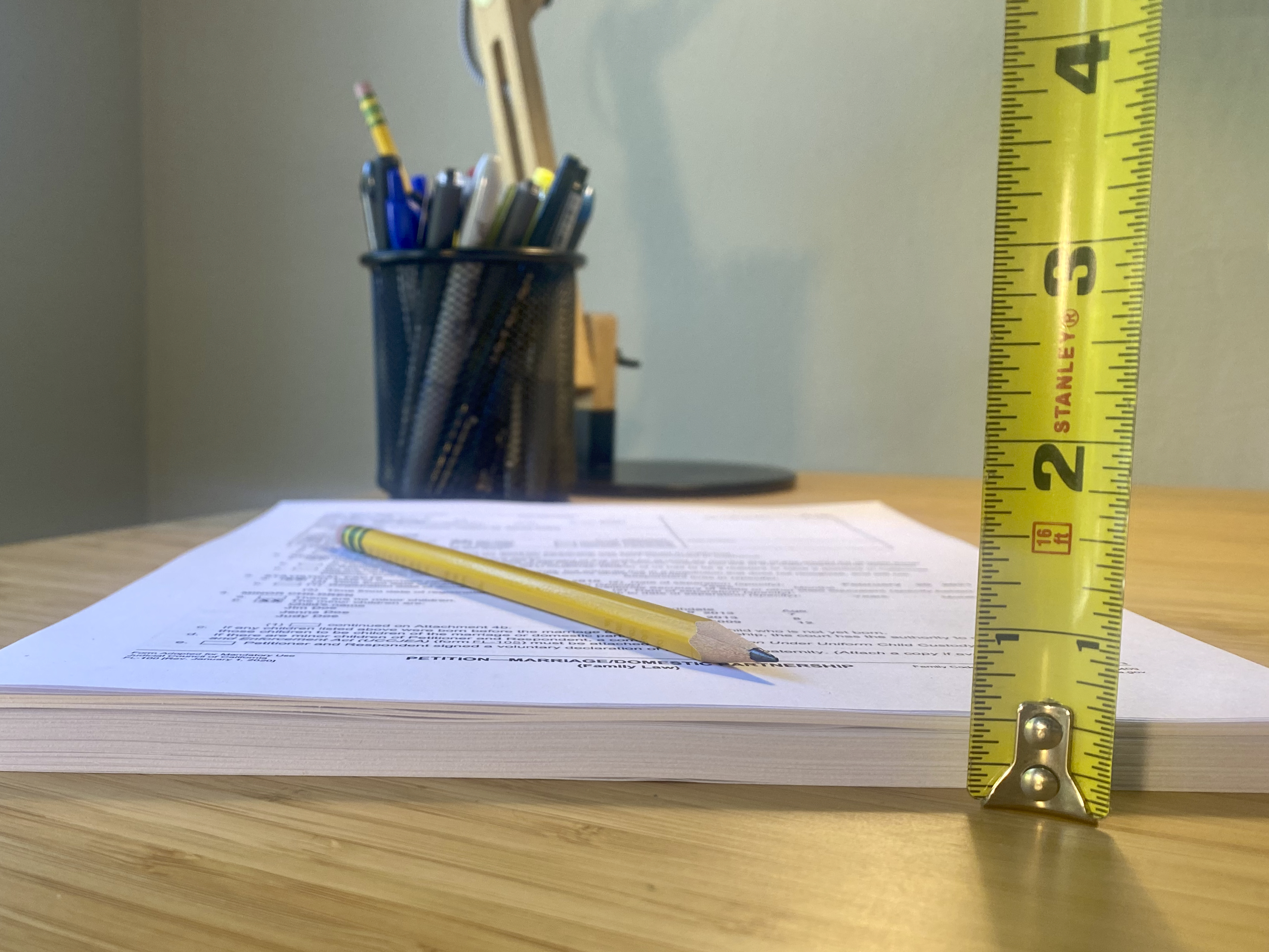 Tape measure in front of stack of papers showing that the forms from 3StepDivorce are half an inch tall when printed.