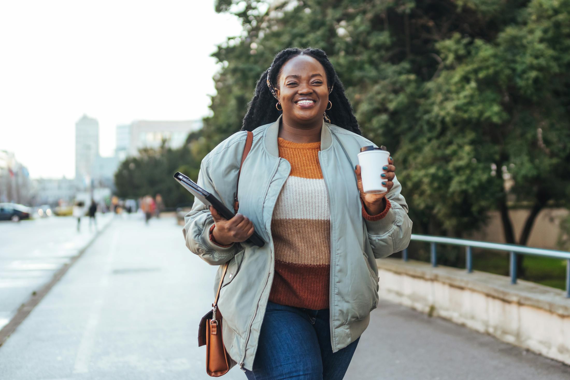 Woman holding a cup of coffee walking outside