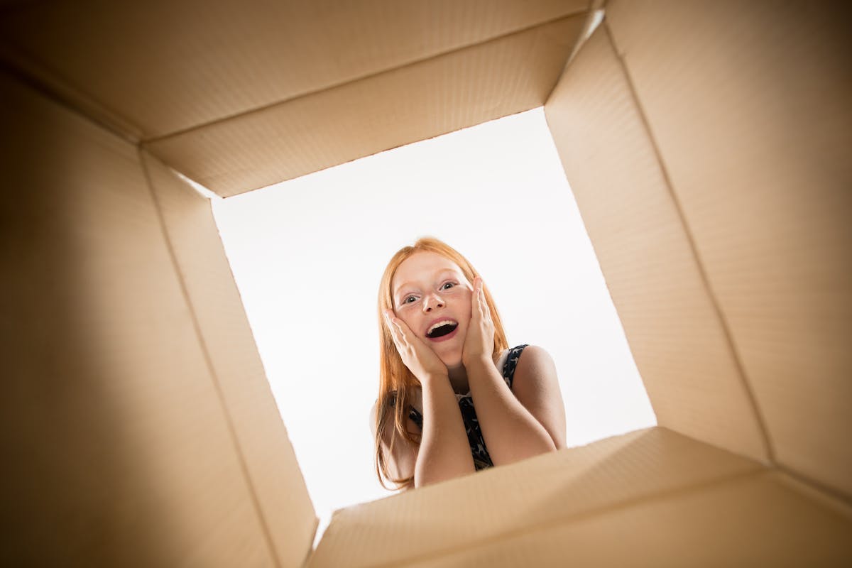 kid-looking-into-cardboard-box-surprise