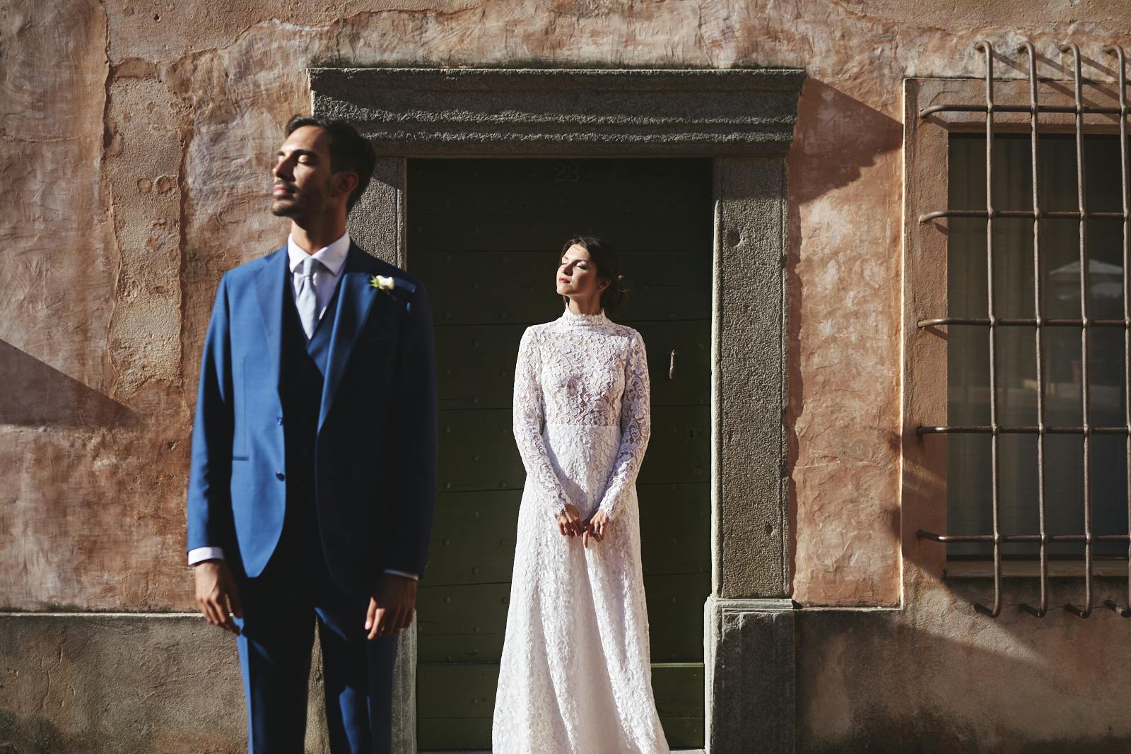 bride and groom staring at the sun in front of italian building newly wed