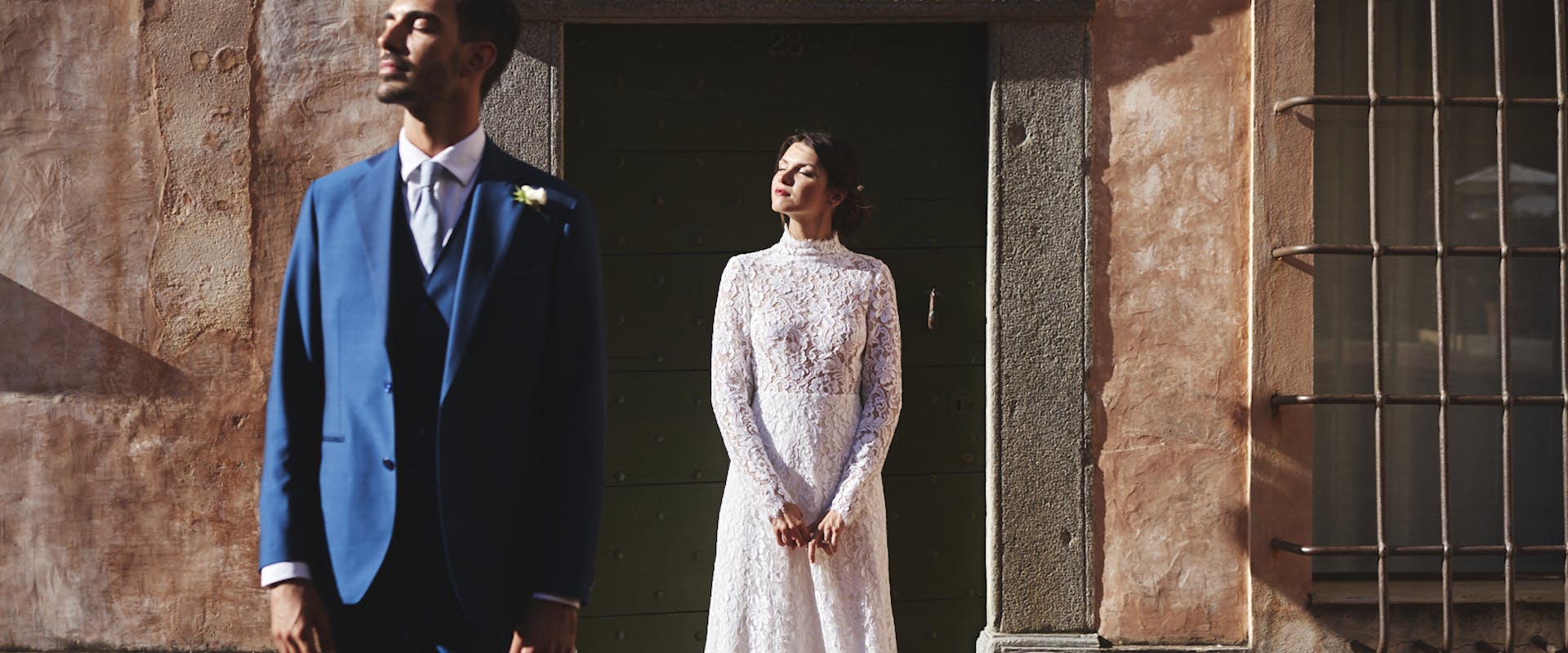bride and groom staring at the sun in front of italian building newly wed
