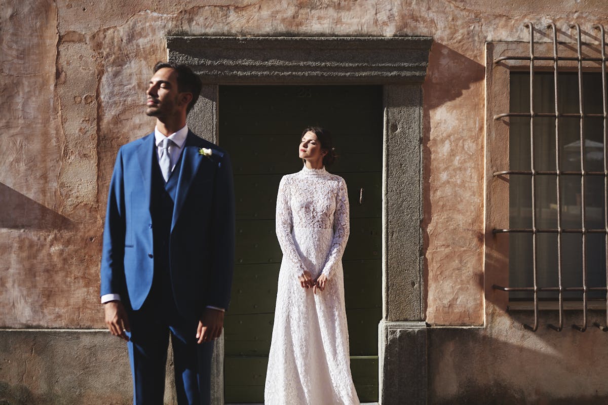 bride and groom staring at the sun in front of italian building newly wed