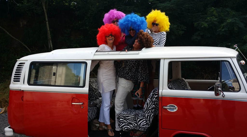 ragazze con parrucche colorate su un pullmino vintage
