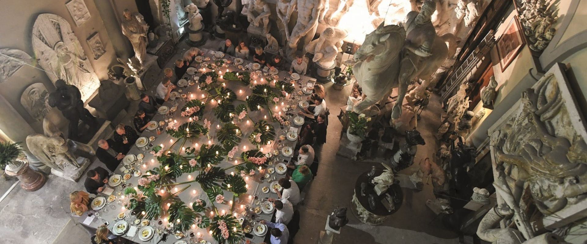 TERRAVENTS gala dinner in a historic building with statues and plants in the middle of the table