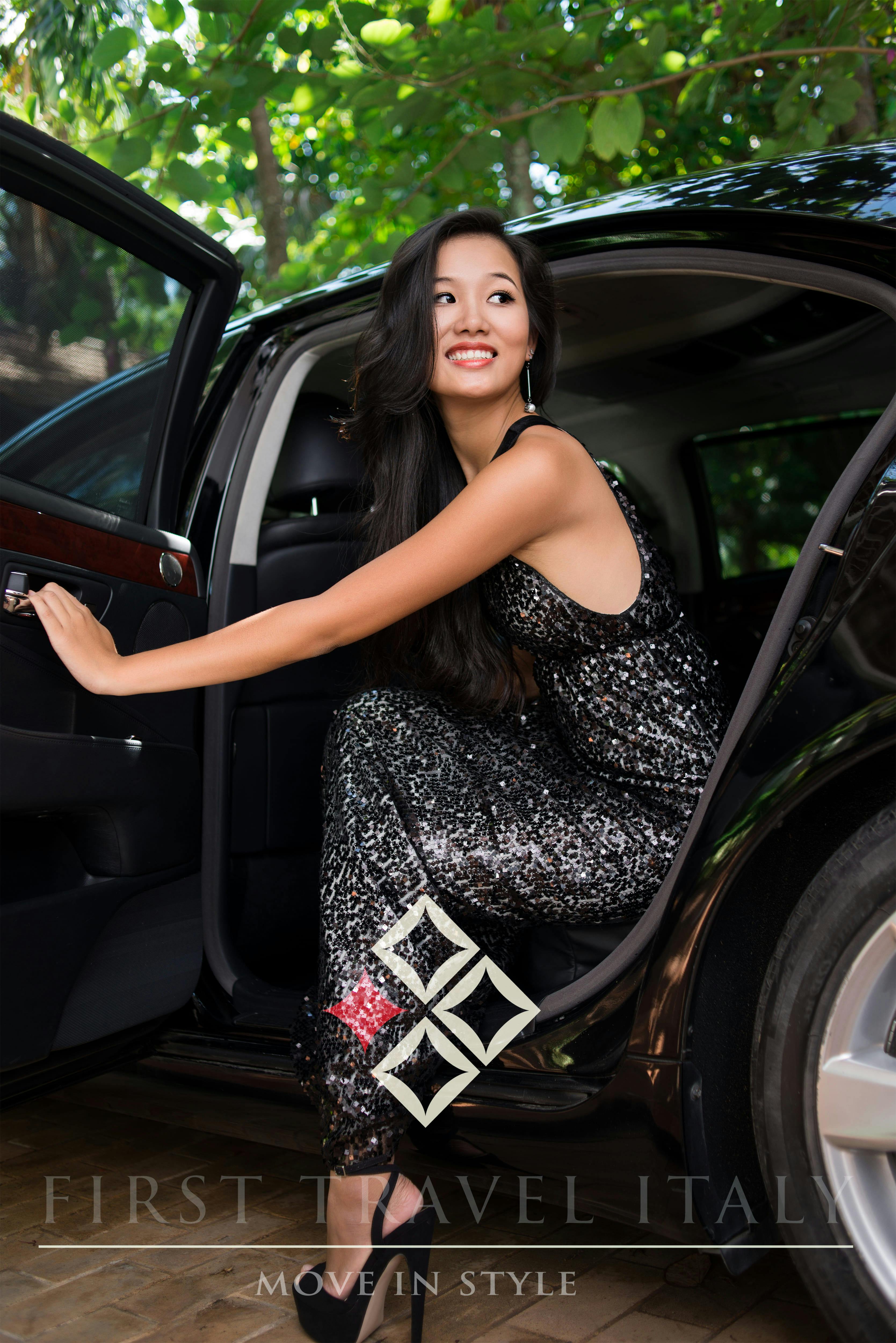 Ragazza vestita elegante che scendo da un'auto