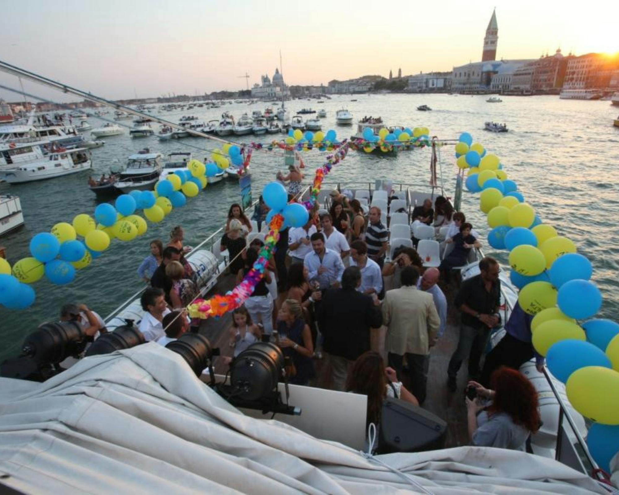 Group of people in a boat with balloons and sea around