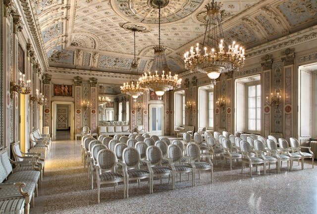 Sala teatrale elegante con pareti bianche affrescate