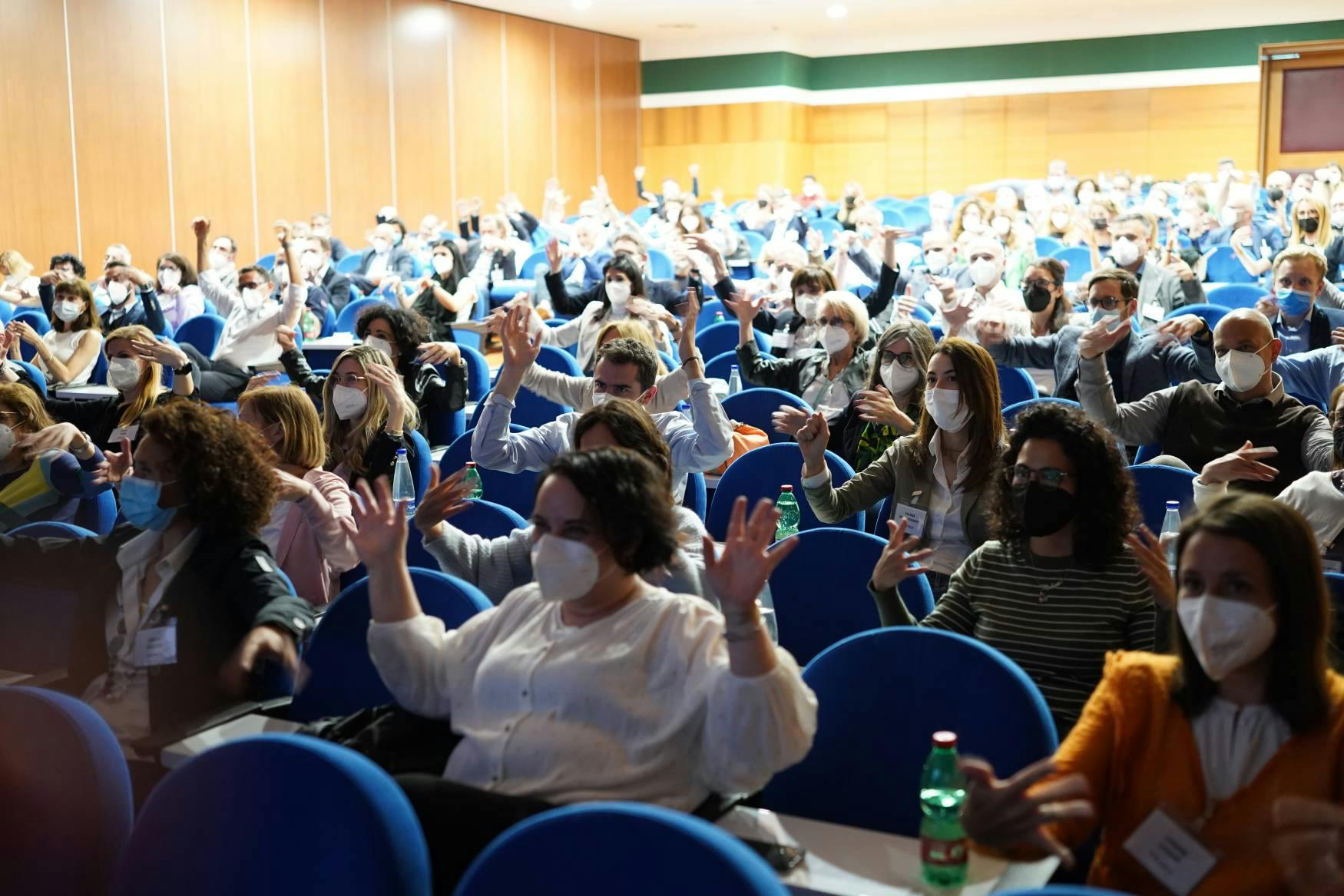 Meeting room with many people and blue chairs