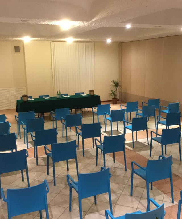 Sala meeting con sedie blu e pareti bianche