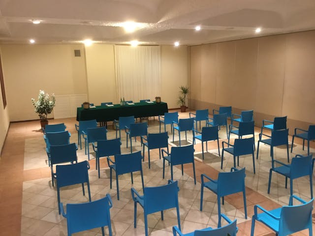 Sala meeting con sedie blu e pareti bianche