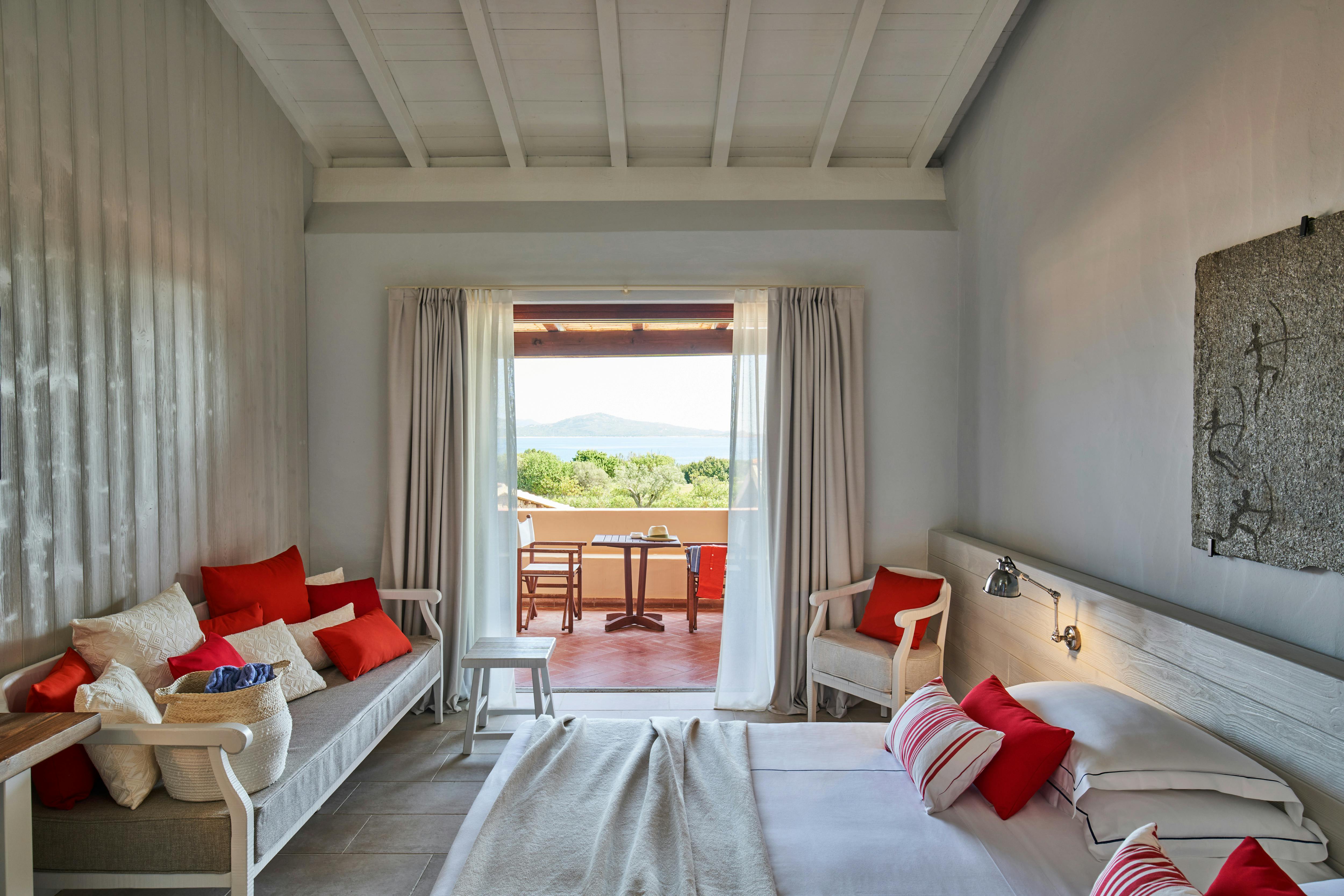 Hotel room with white walls and red pillows