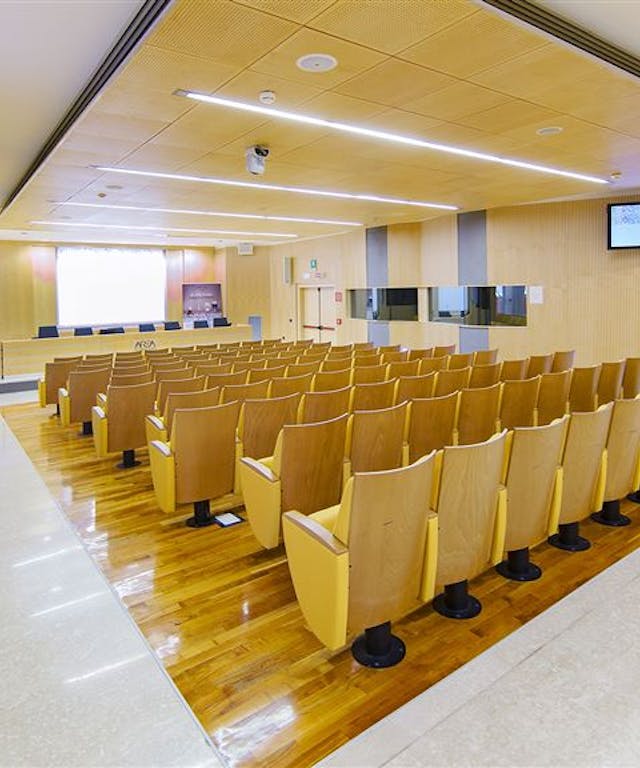 Sala meeting con sedie di legno e pavimento bianco