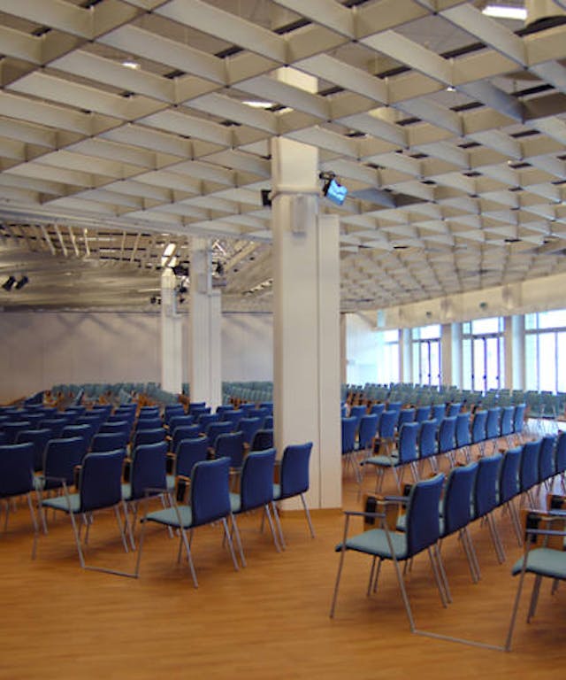 Sala meeting "Stazione Marittima" con sedie blu e pavimento di legno