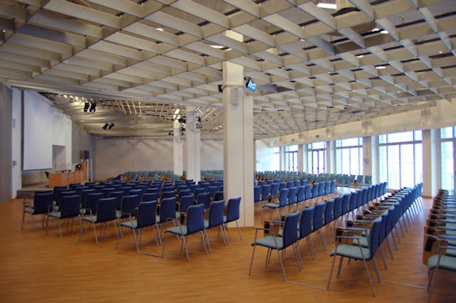 Sala meeting "Stazione Marittima" con sedie blu e pavimento di legno