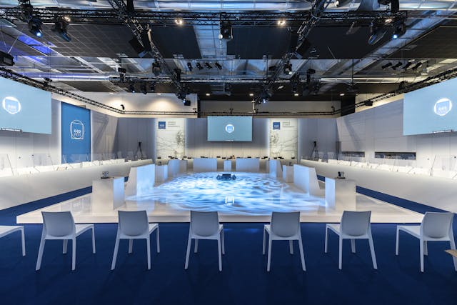 Sala meeting con pavimento blu e sedie bianche