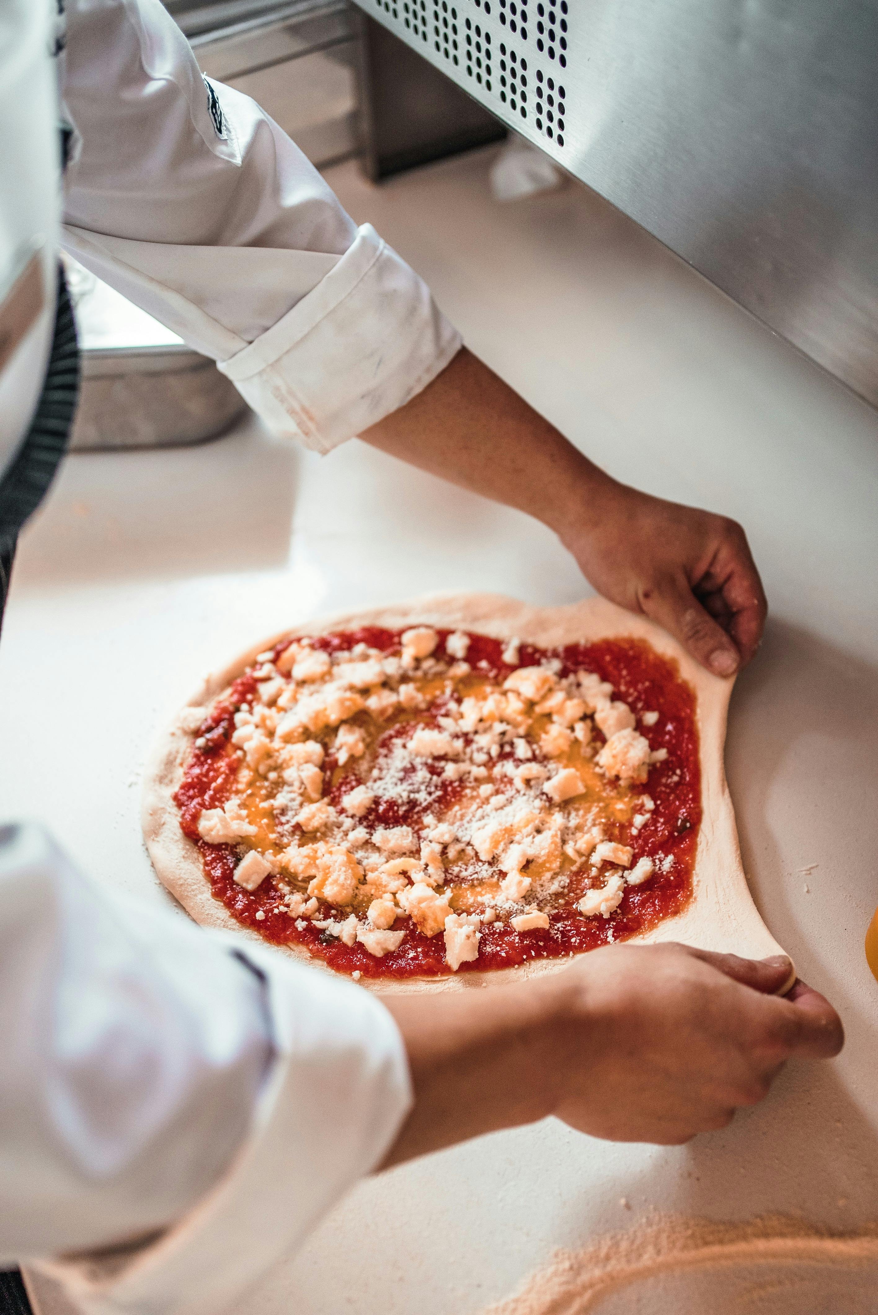 Person cooking a homemade pizza