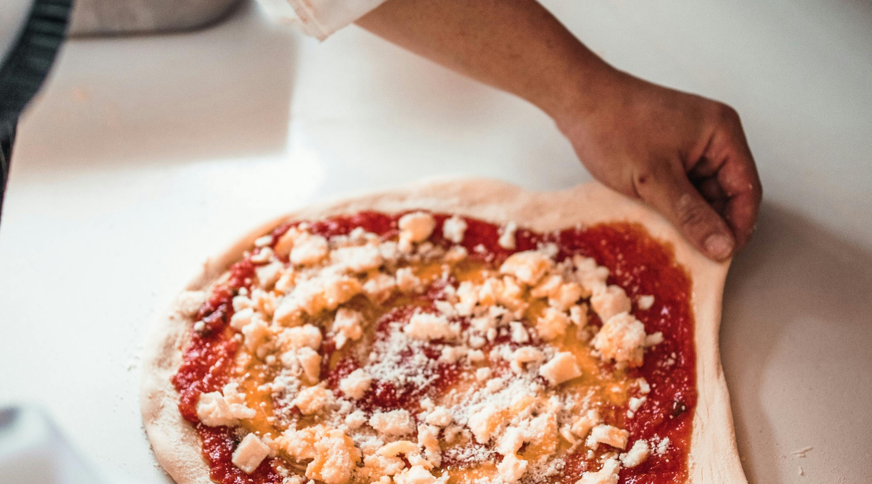 Person cooking a homemade pizza