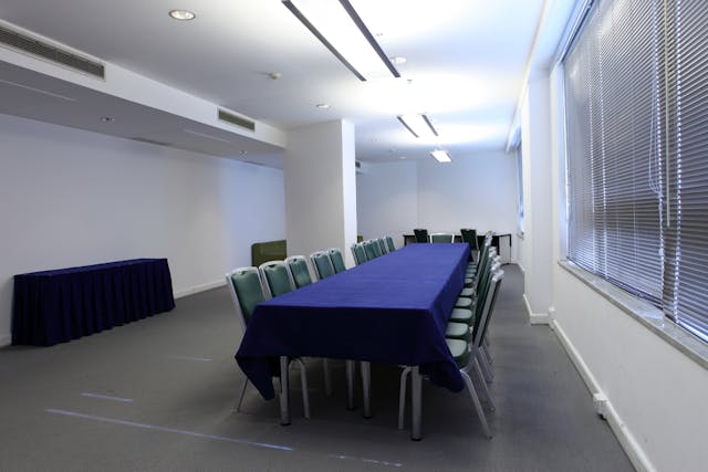 Sala riunioni con tavolo blu e sedie e pareti bianche