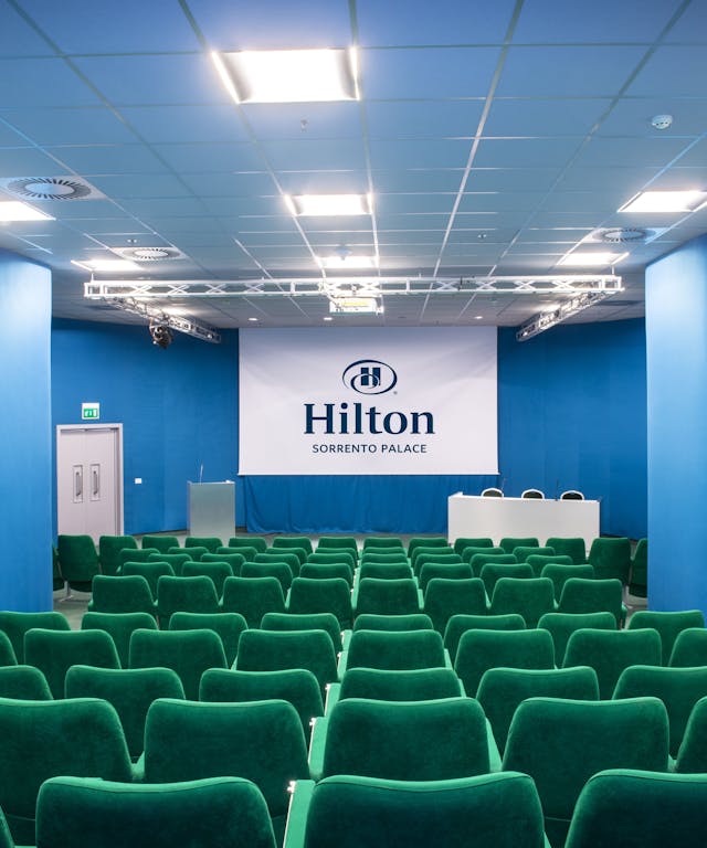 Sala riunioni con sedie verdi e pareti blu