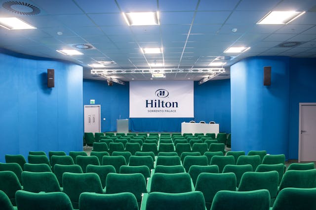Sala riunioni con sedie verdi e pareti blu