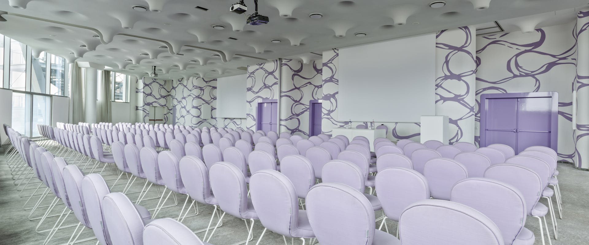 Sala riunioni con pavimento bianco, sedie bianche e pareti bianche