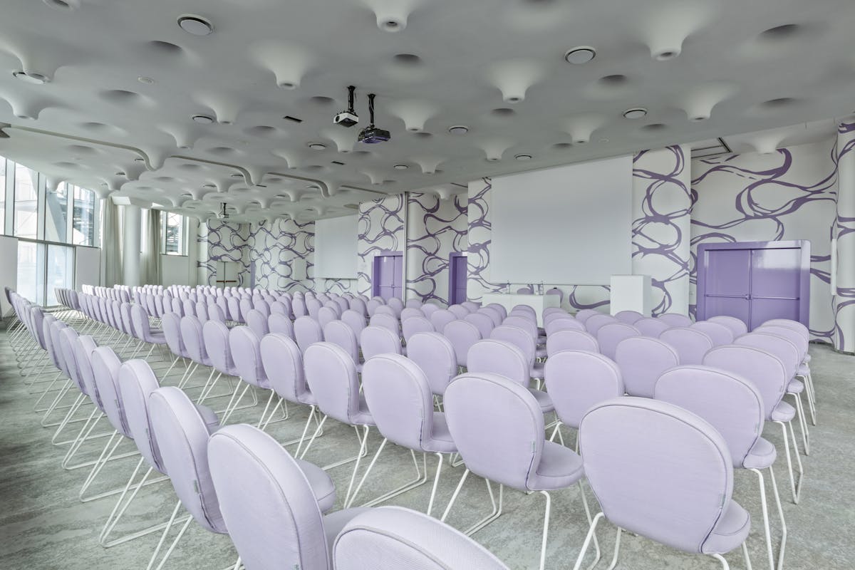Sala riunioni con pavimento bianco, sedie bianche e pareti bianche