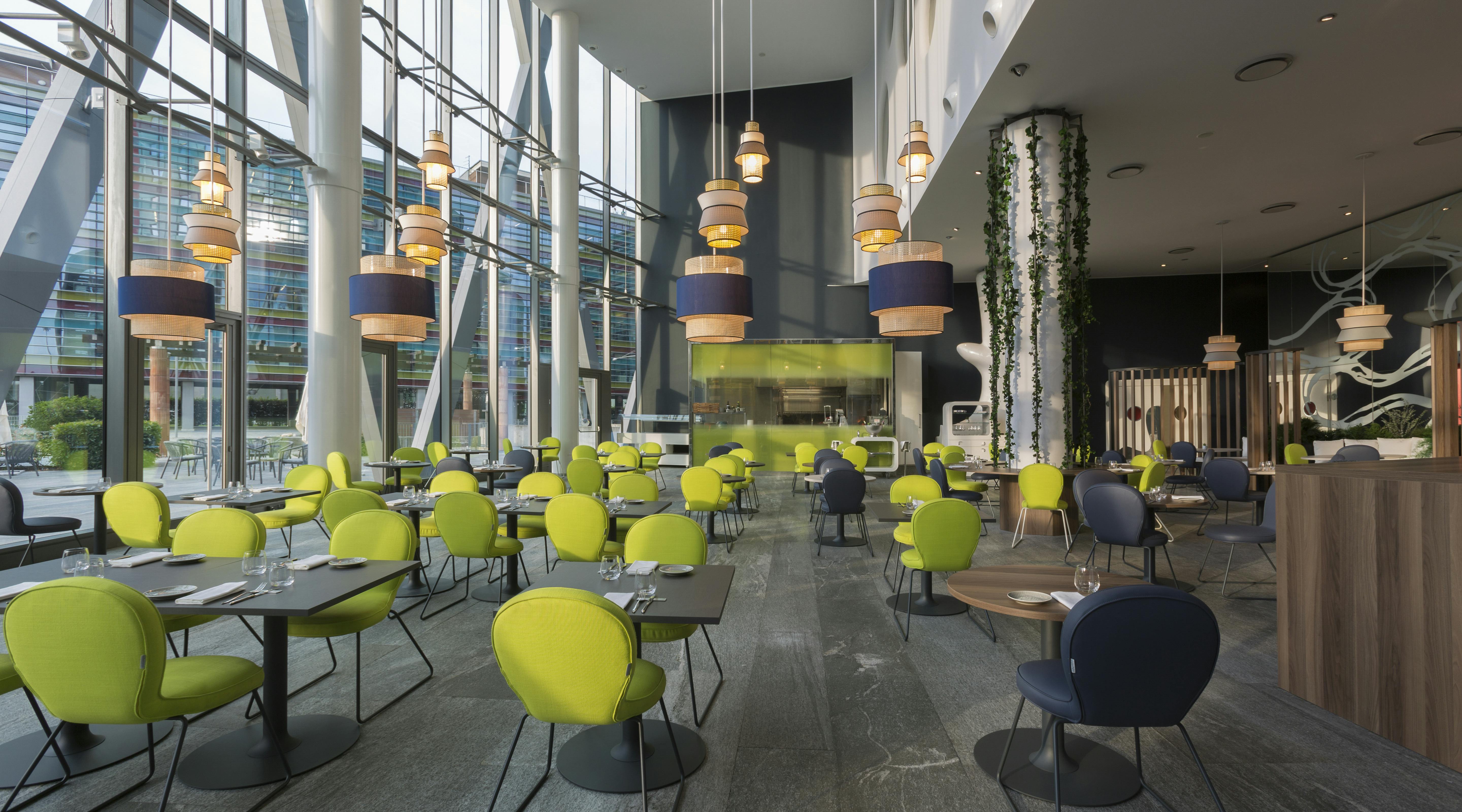 Area ristorante di hotel con sedie gialle e pavimento di legno