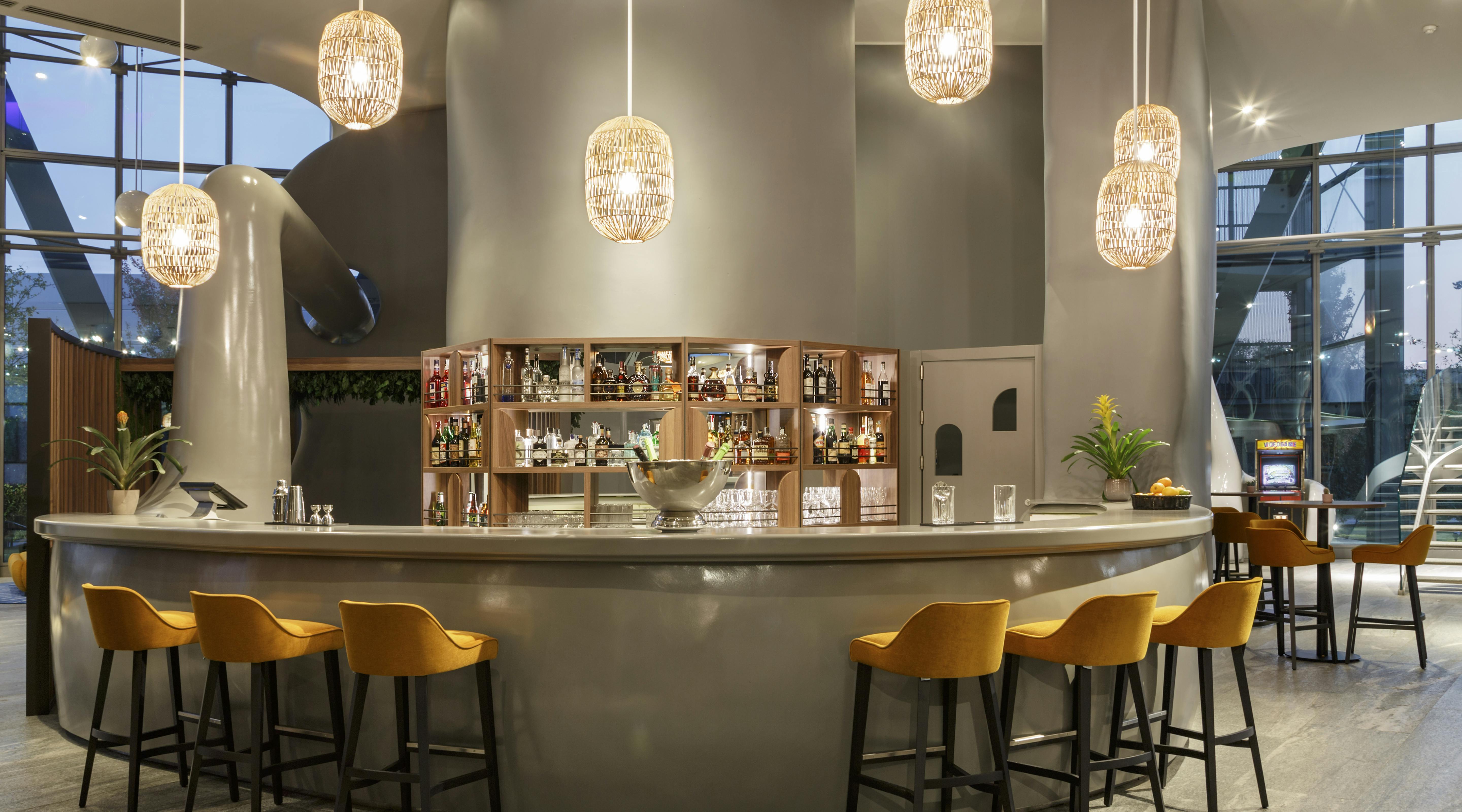 Bar station with yellow chairs and hanging lamps