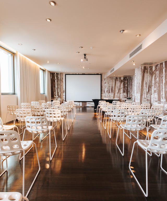 Lounge meeting room with white chairs and wooden floor