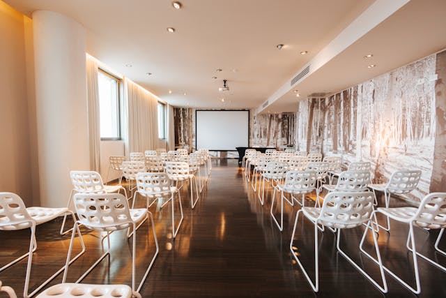 Sala riunioni Lounge con sedie bianche e pavimento in legno