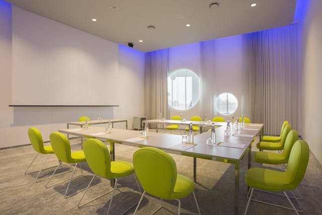 Sala riunioni con sedie gialle e pareti bianche
