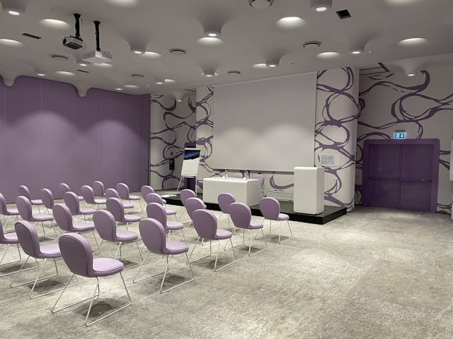 Sala riunioni con sedie e pareti rosa