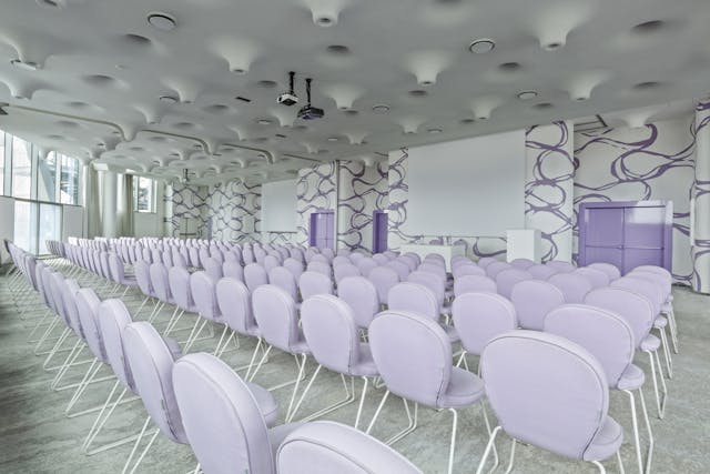 Sala riunioni con pavimento bianco, sedie bianche e pareti bianche