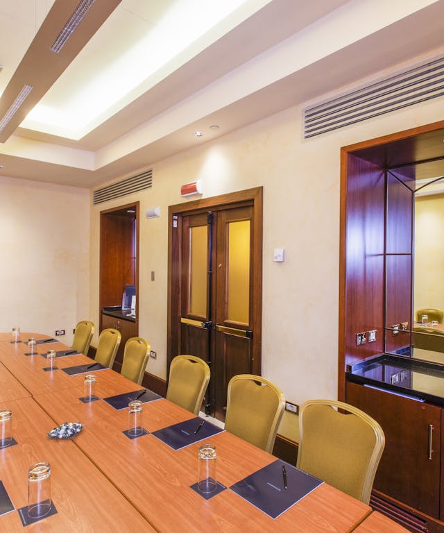 Sala meeting-tavolo di legno-sedie gialle-finestre