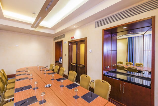 Sala meeting-tavolo di legno-sedie gialle-finestre