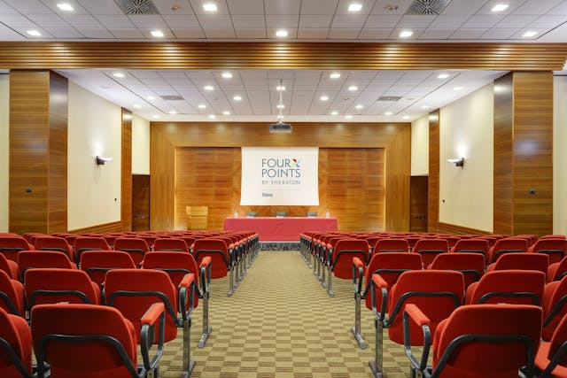 Meeting room with red chairs and stage