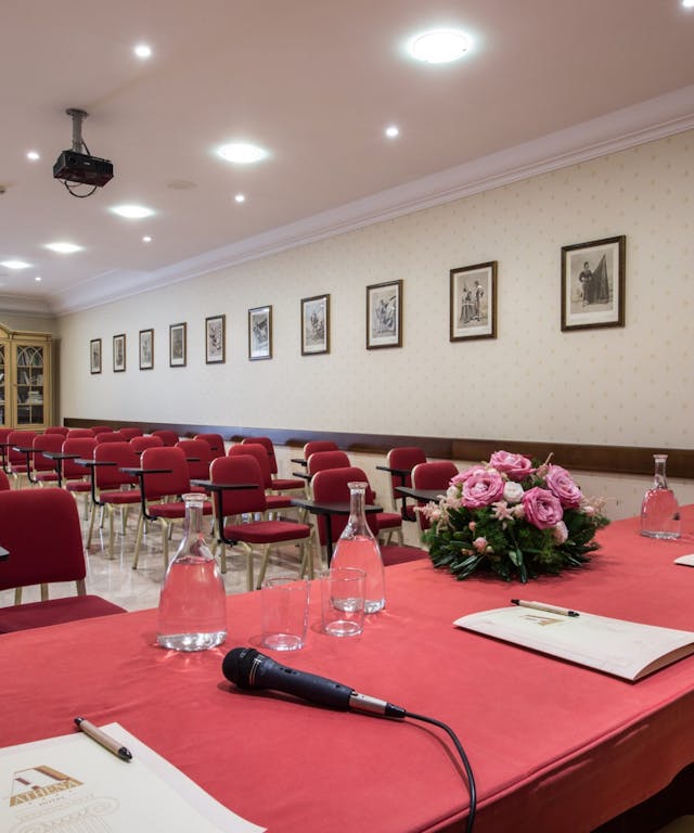 Sala meeting con tavolo e sedie rosse e fiori