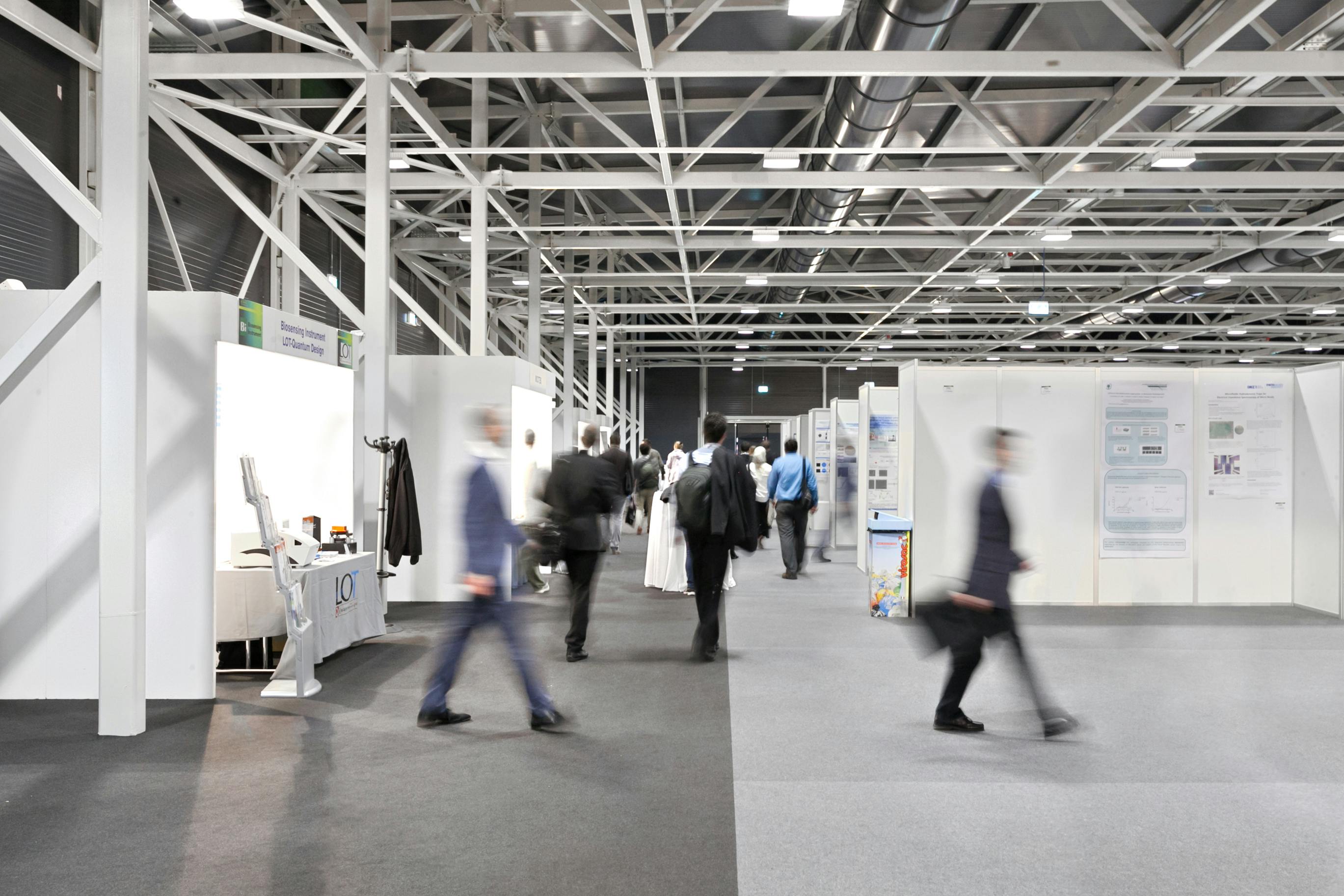 Exhibition hall with stands and people on the move
