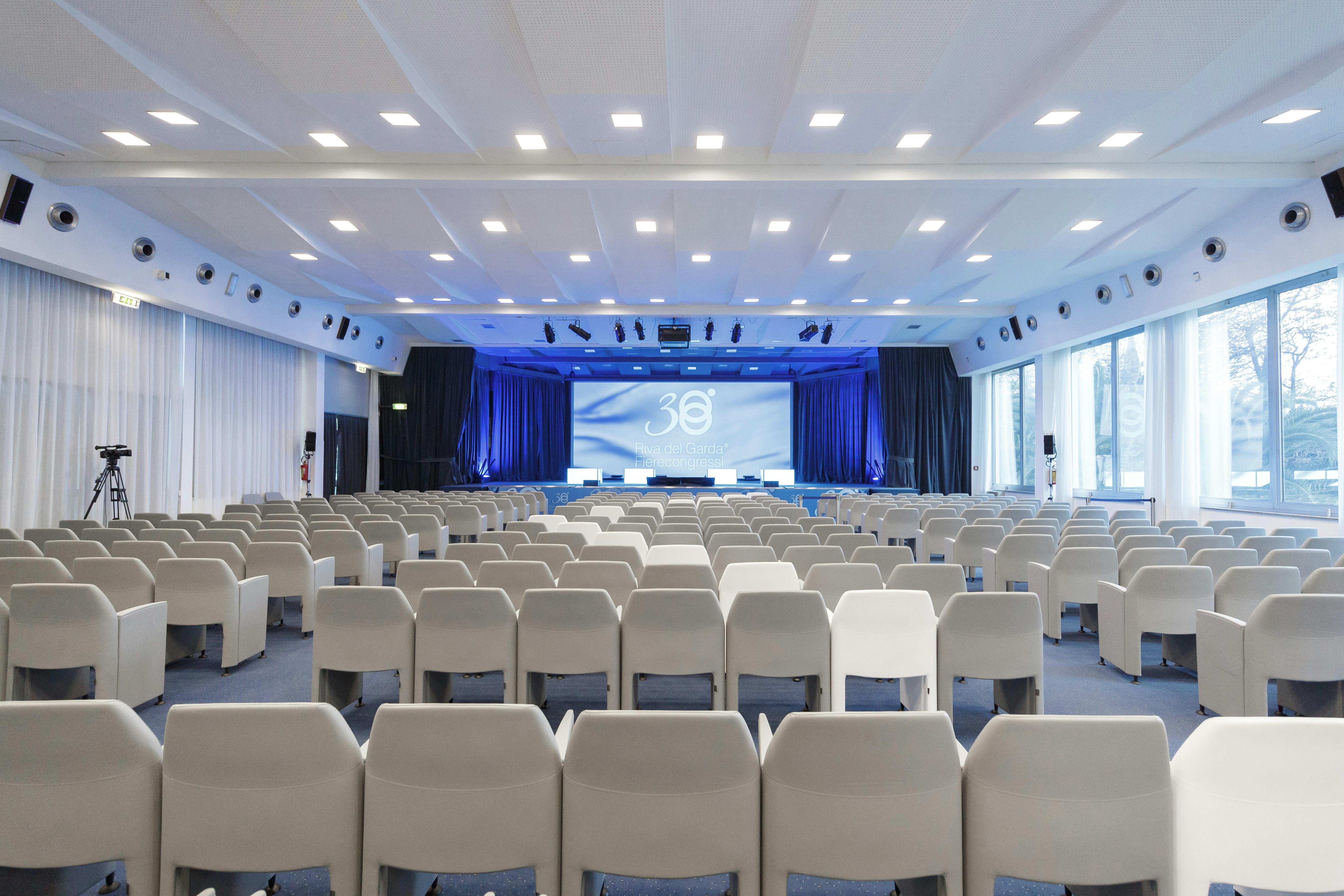 Meeting room with white chairs and blue curtains