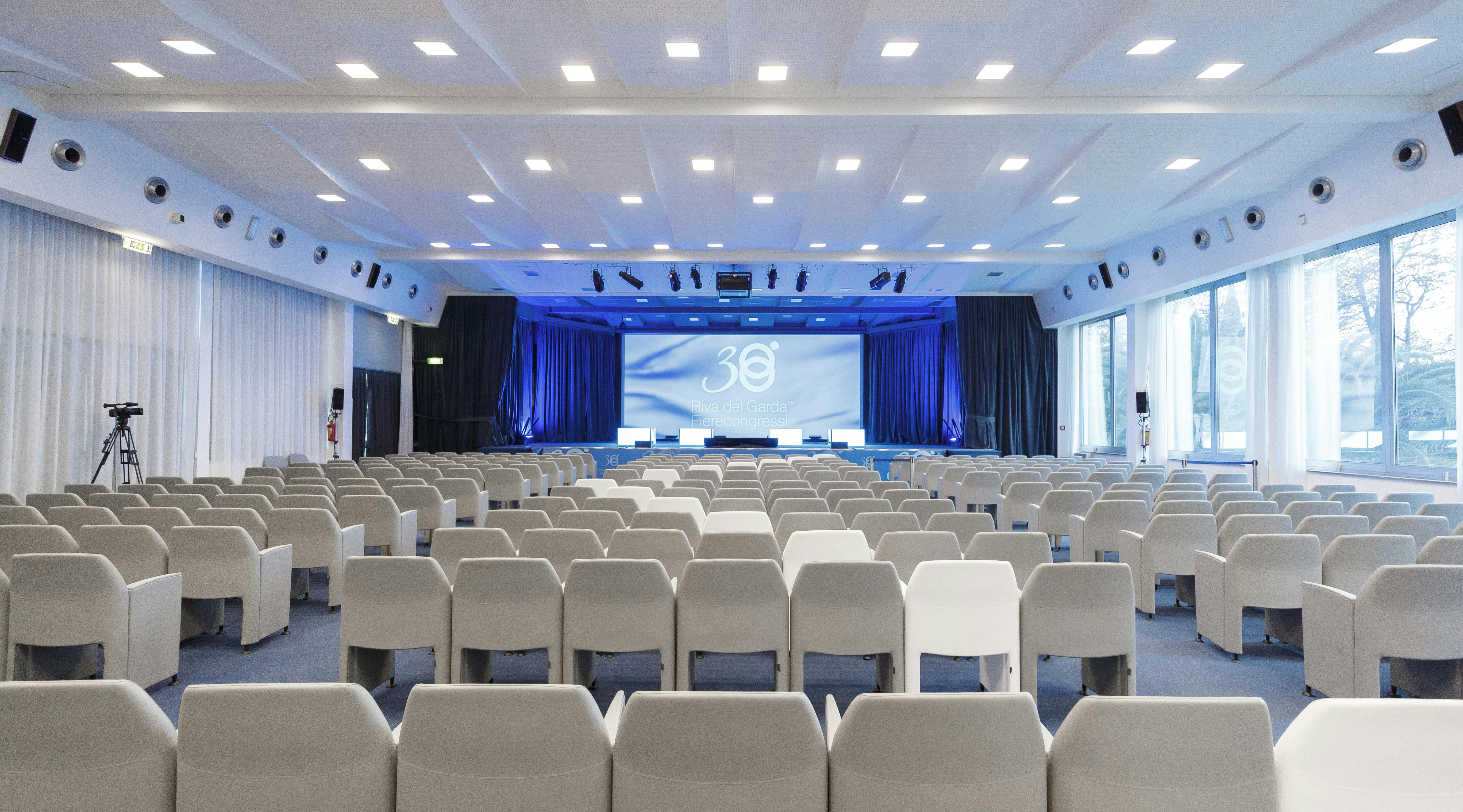 Meeting room with white chairs and blue curtains